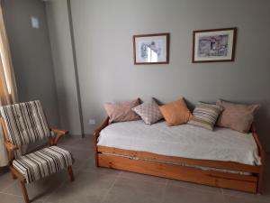 Una cama con almohadas y una silla en una habitación. en APART VITTA en Río Cuarto