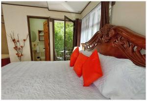 a bedroom with a large bed with orange pillows at Dreams Lodge in Monteverde Costa Rica