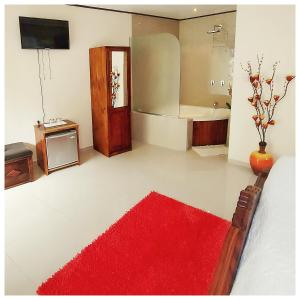 a bathroom with a red rug and a bath tub at Dreams Lodge in Monteverde Costa Rica
