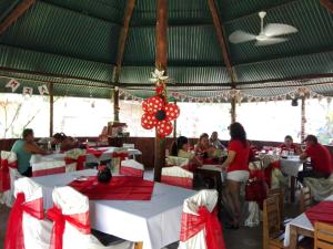 a group of people sitting at tables in a restaurant at Hotel Cabanas La Teca in Liberia