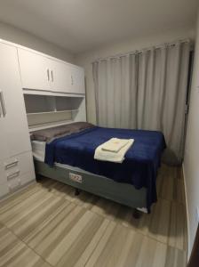 a small bedroom with a bed with a blue blanket at Studio A completo 400m da praia in Porto De Galinhas