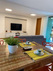 ein Wohnzimmer mit einem Tisch und einem Sofa in der Unterkunft Village Summer Ville Pé na Areia in Itacimirim