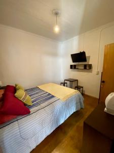 a bedroom with a bed and a flat screen tv at Hostal Mirenart in Valparaíso