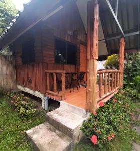 a cabin with a deck with a table and chairs at NonKan HomeStay นอนกาญจน์ โฮมสเตย์ in Kanchanaburi City