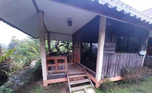 Cette petite maison dispose d'une terrasse couverte en bois et d'un escalier. dans l'établissement NonKan HomeStay นอนกาญจน์ โฮมสเตย์, à Kanchanaburi