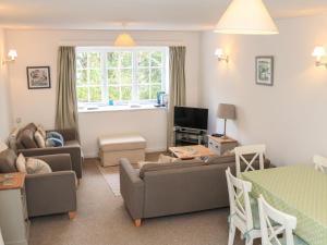 a living room with a couch and a table at 3 Moult Farm Cottage in Salcombe