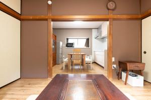 a living room with a table and a kitchen at 箱根湯本 川風荘 - Hakone Yumoto Kawakazesou in Hakone