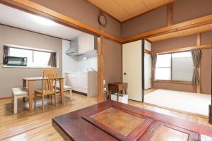 箱根湯本 川風荘 - Hakone Yumoto Kawakazesou في هاكوني: غرفة معيشة مع طاولة وغرفة طعام