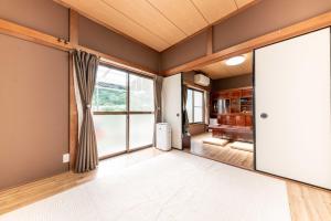 an empty living room with a large sliding door at 箱根湯本 川風荘 - Hakone Yumoto Kawakazesou in Hakone