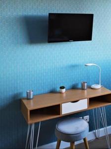 escritorio de madera con silla y TV en la pared en T2 Neuf Lattes entre la VILLE, MER, NATURE 10 mn en Lattes