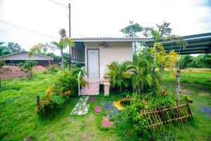 una pequeña casa con un jardín frente a ella en Nonplern Garden Home Khaoyai en Ban Noen Hom