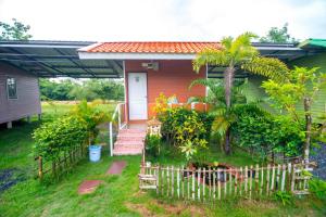 une petite maison avec une clôture devant elle dans l'établissement Nonplern Garden Home Khaoyai, à Ban Noen Hom