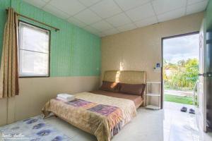1 dormitorio con cama y ventana grande en Nonplern Garden Home Khaoyai en Ban Noen Hom