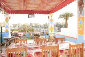 アスワンにあるNuba Doolのテーブルと椅子、パティオ付きのレストラン