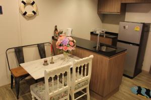 a kitchen with a table with a vase of flowers on it at Rain ChaAm-HuaHin JN in Cha Am
