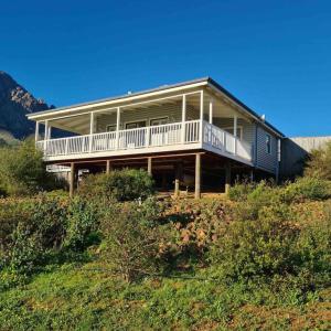 a large house sitting on top of a hill at Exquisite chalet on private nature reserve in Wolseley