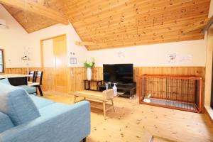 ein Wohnzimmer mit einem blauen Sofa und einem TV in der Unterkunft 白浜ホープヒルズ　N-33号棟 in Shirahama