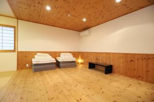 2 Betten in einem holzvertäfelten Zimmer in der Unterkunft 白浜ホープヒルズ　N-33号棟 in Shirahama