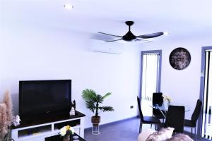 a living room with a flat screen tv and a table at Lakeside Residence in Raymond Terrace