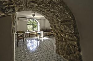 a living room with a stone wall and a couch at The Nest - A Romantic Vacation Home in Ein Kerem - Jerusalem in Jerusalem