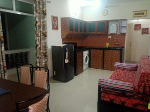 cocina con nevera, mesa y sillas en Asian Paradise comfort en Varca