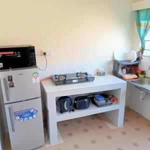 uma pequena cozinha com um fogão e um frigorífico em Twende Nanyuki Homes em Nanyuki
