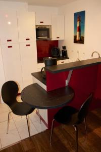 una cocina con mesa y 2 sillas y un faro en Tag am Meer Sylt, en Westerland