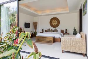- une chambre avec un lit, un canapé et une télévision dans l'établissement Dhevatara Residence Sea View Villas, à Bophut 