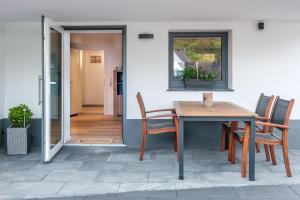 a wooden table and chairs on a patio at Terraluna-Heimbach in Heimbach