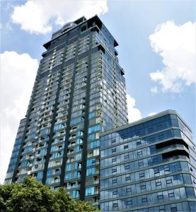 プノンペンにあるThe Penthouse Residenceの青空を背景にした高いガラス張りの建物