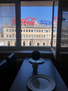 a table with two plates and a potted plant on it at Square Vanilla Apartments in Skopje