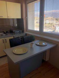 a kitchen with a table with two plates and a plant on it at Square Vanilla Apartments in Skopje