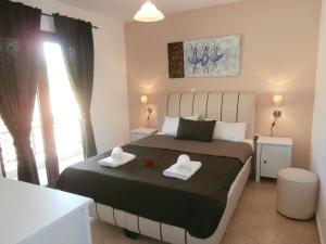 a bedroom with a bed with two towels on it at Villa Fun & Sun in Limenaria