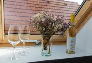 una mesa con tres copas de vino y un jarrón con flores en Takács Pince apartman, en Hajós
