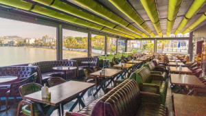 a restaurant with tables and chairs and a view of the water at Marti Beach Hotel in Kuşadası