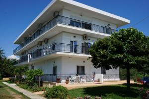 a white apartment building with balconies and a tree at Kymata by Anastasia in Stavros
