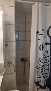 a bathroom with a shower with a toilet and a shower curtain at Lavender Home in Volos +34 photos