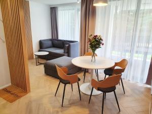 ein Wohnzimmer mit einem Sofa, einem Tisch und Stühlen in der Unterkunft RelaxApart - Komfortowy apartament Kalinowa in Szczyrk