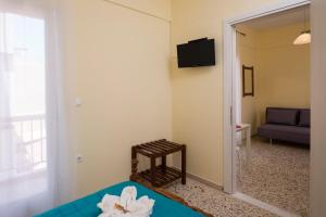 a room with a bed and a chair and a mirror at Penelopi Rooms in Chania Town