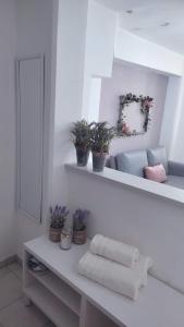 a white bathroom with a mirror and towels on a counter at Lavender Home in Volos