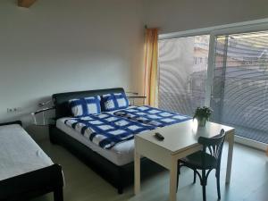 1 dormitorio con cama, mesa, cama y ventana en Ferienwohnung Christina, en Ried im Zillertal