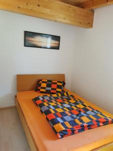 Una cama en una habitación blanca con una manta. en Ferienwohnung Christina, en Ried im Zillertal