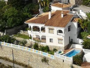 a white house with a red roof at House in a cove Almunecar in Almuñécar