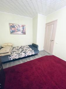 コヴロフにあるApartment on Furmanova 16のベッドルーム1室(ベッド1台、赤いラグ付)