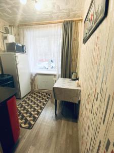 コヴロフにあるApartment on Furmanova 16のテーブルと冷蔵庫付きの小さな部屋
