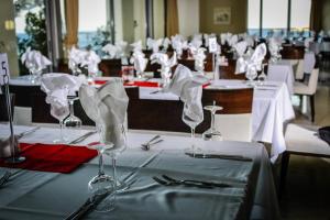 a row of tables with wine glasses and napkins at Konstantinos Palace in Karpathos
