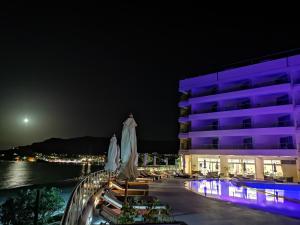 a hotel with a pool and a building at night at Konstantinos Palace in Karpathos