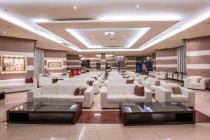 a waiting room with white couches and tables at Konstantinos Palace in Karpathos