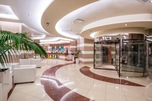 a lobby with a glass elevator in a building at Konstantinos Palace in Karpathos