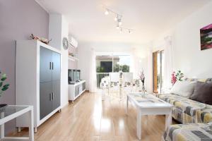 a white living room with a couch and a table at MARCOS Apt in Port de Pollensa